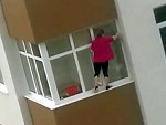 Cleaning Her Apartment Windows Without A Care In The World
